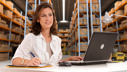 Female administrative in a desk with a distribution warehouse in